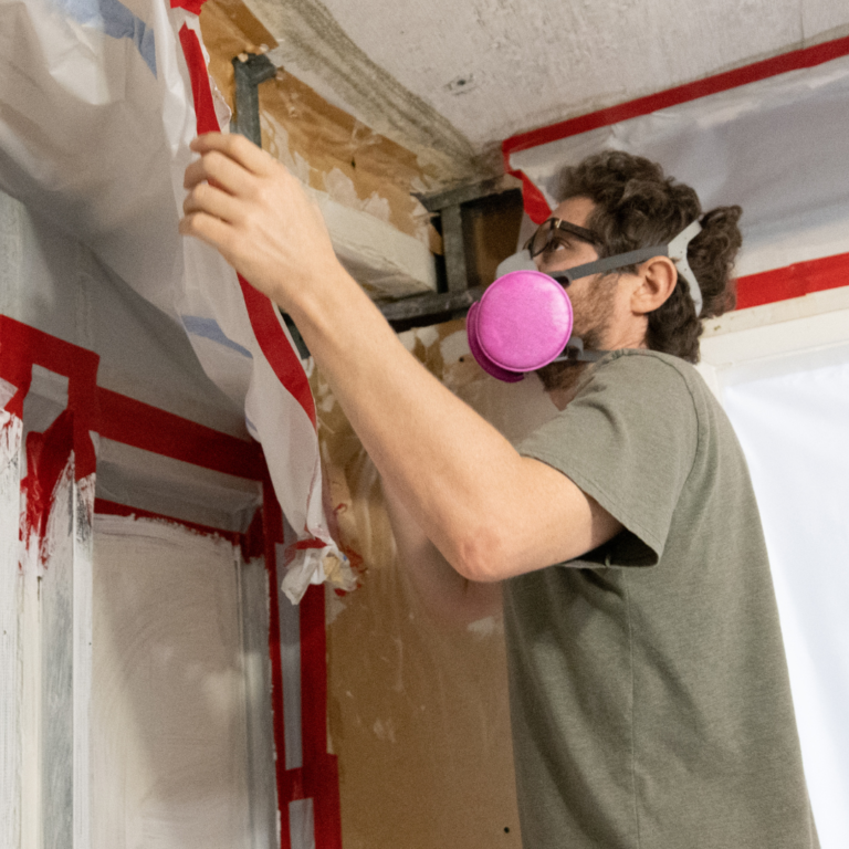 Man wearing respirator renovating home